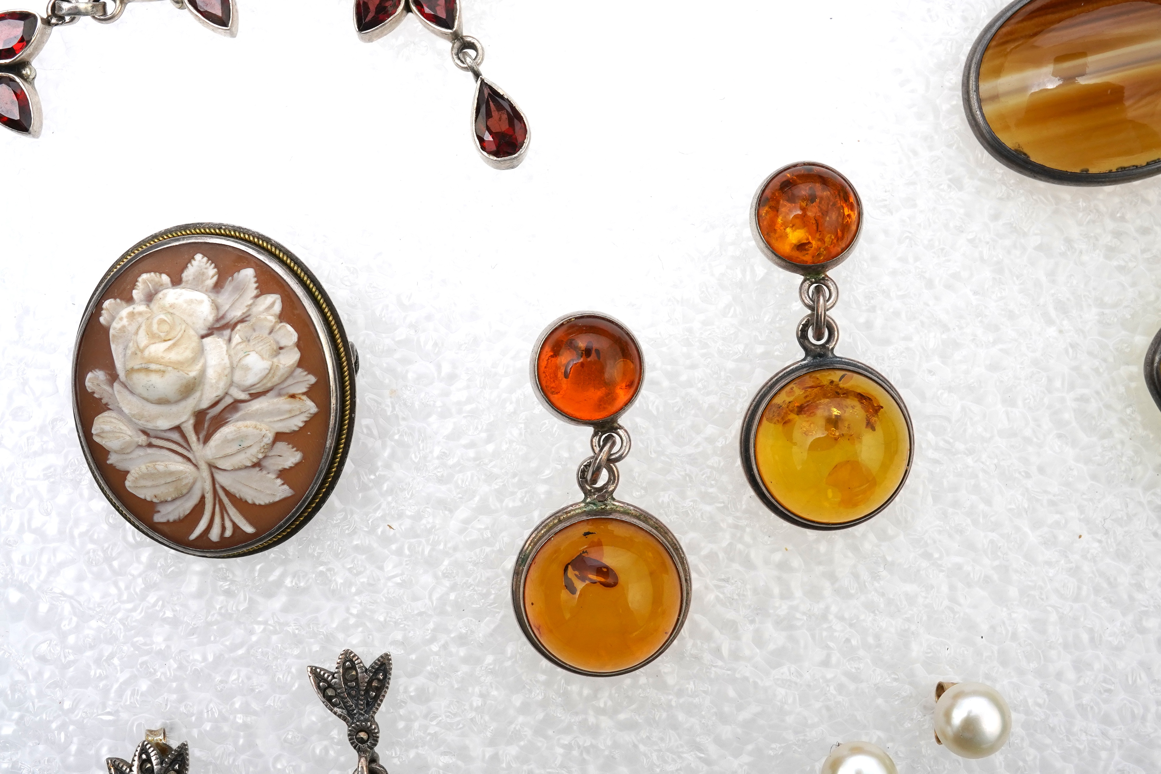 A small collection of costume jewellery to include a silver curb link charm bracelet, hung with assorted bezel set agate and carnelian drops, together with other silver and costume jewellery